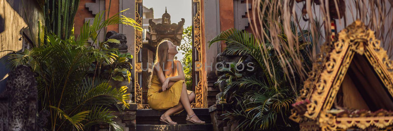 Young woman tourist on the background of Balinese doors. Bali Travel Concept BANNER, LONG FORMAT by galitskaya