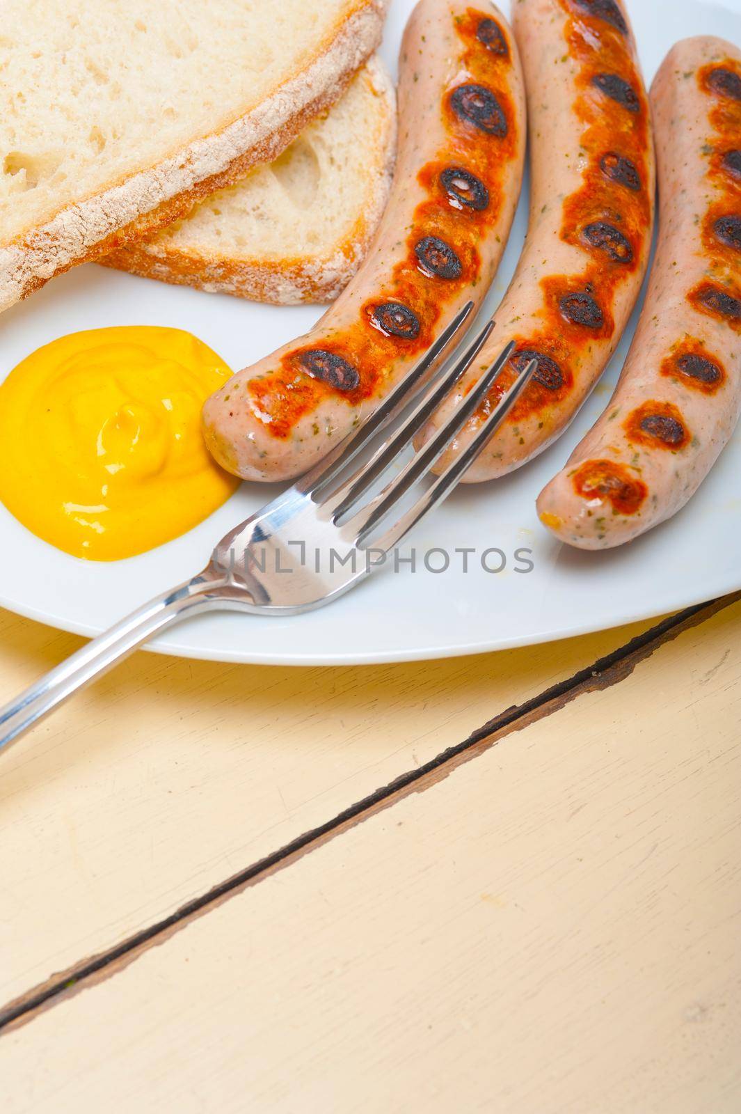 traditional fresh German wurstel sausages grilled with yellow mustard 