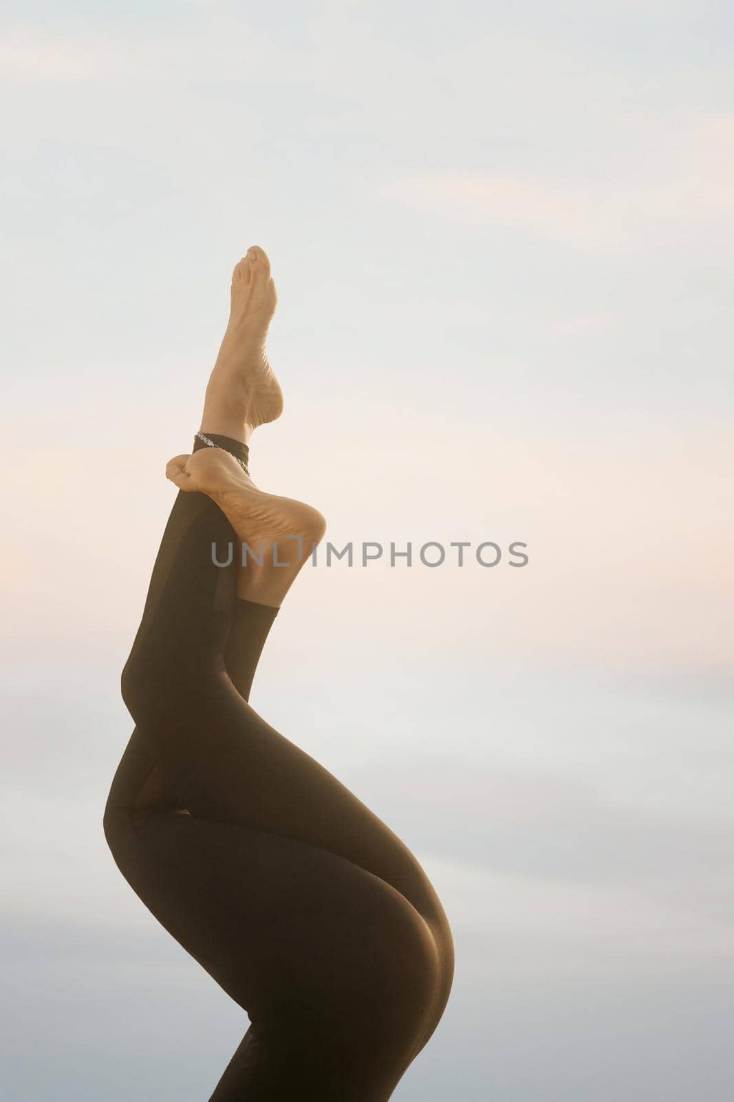 Woman's legs in yoga position in nature. by SerhiiBobyk
