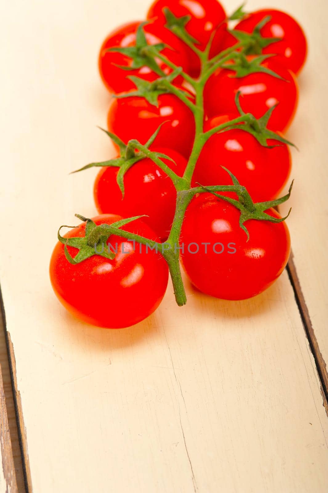 fresh cherry tomatoes on a cluster by keko64