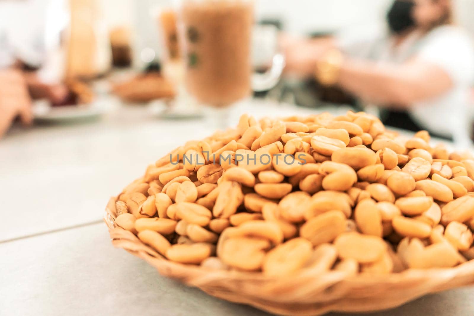 Roasted white coffee beans in a cafeteria with the background out of focus where the workers are and the drinks prepared by cfalvarez