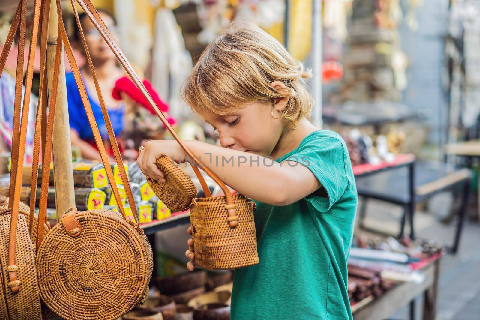 Boy at a market in Ubud, Bali. Typical souvenir shop selling souvenirs and handicrafts of Bali at the famous Ubud Market, Indonesia. Balinese market. Souvenirs of wood and crafts of local residents by galitskaya
