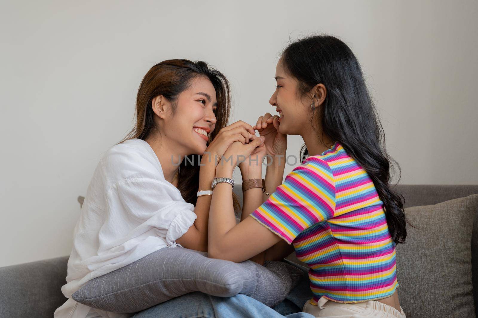 Happy lesbian, pleasure asian young two women, girl gay or close friend, couple love moment spending good time together on sofa at home. Activity of leisure, relax
