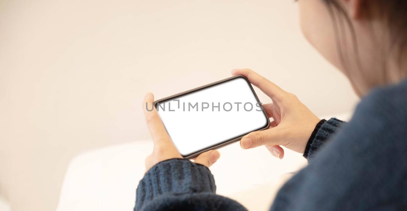 Top view of woman hands holding smart phone with blank copy space screen for your text message or information content. by wichayada