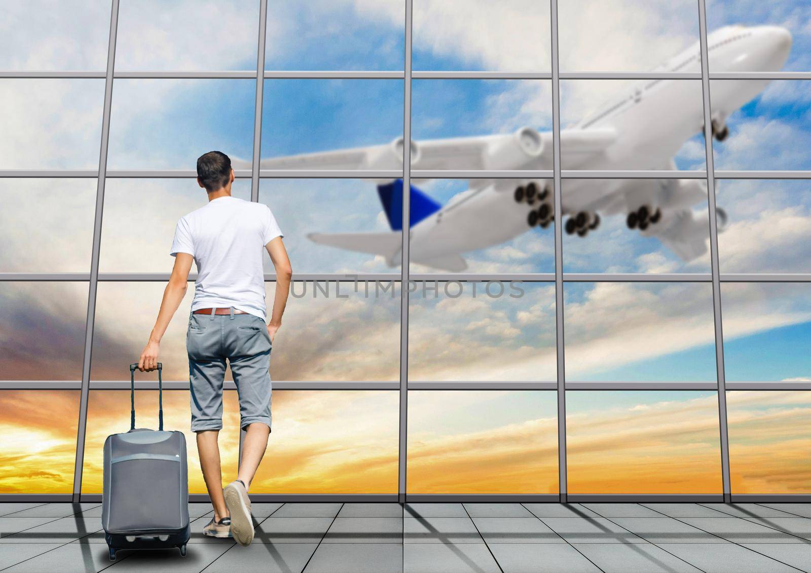 Young man walking in the airport terminal with suitcase luggage. Travel lifestyle concept by Andelov13