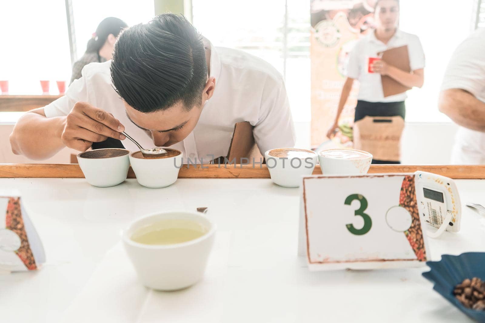 Professional cupper examining and tasting a coffee with a metal spoon in Matagalpa Nicaragua