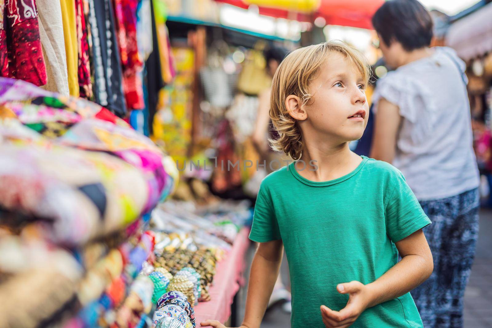 Boy at a market in Ubud, Bali. Typical souvenir shop selling souvenirs and handicrafts of Bali at the famous Ubud Market, Indonesia. Balinese market. Souvenirs of wood and crafts of local residents by galitskaya