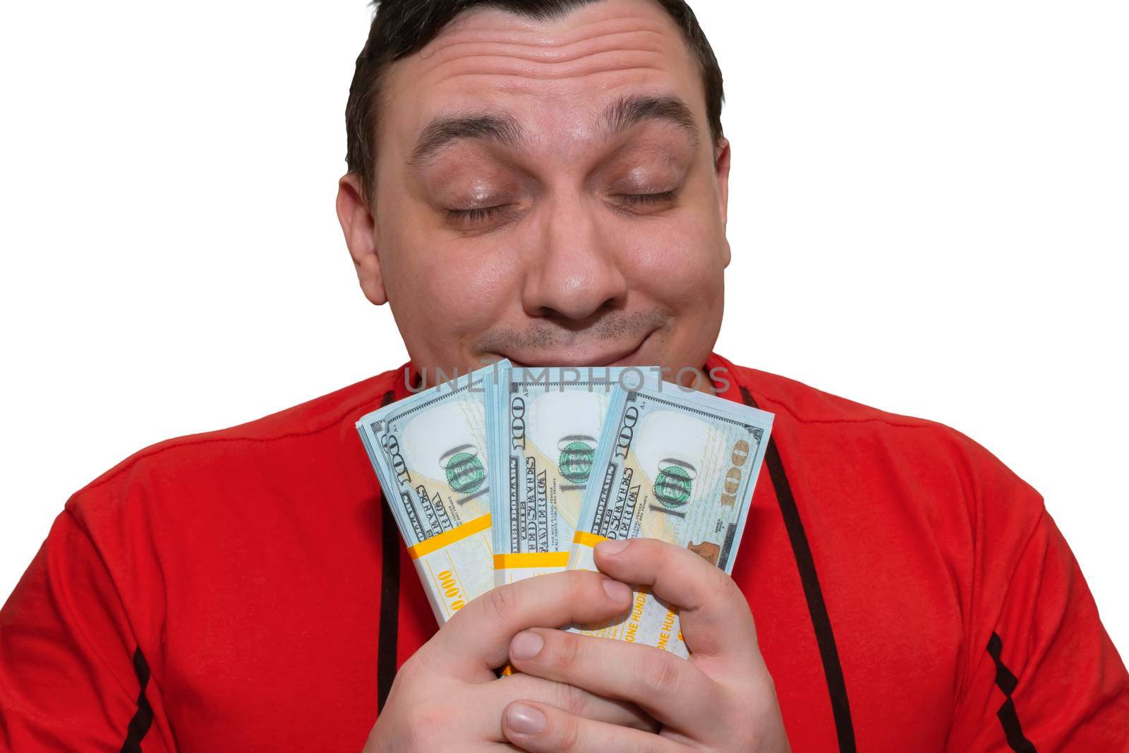 A happy man inhales the aroma of cash while holding it in his hands. Concept of financial success
