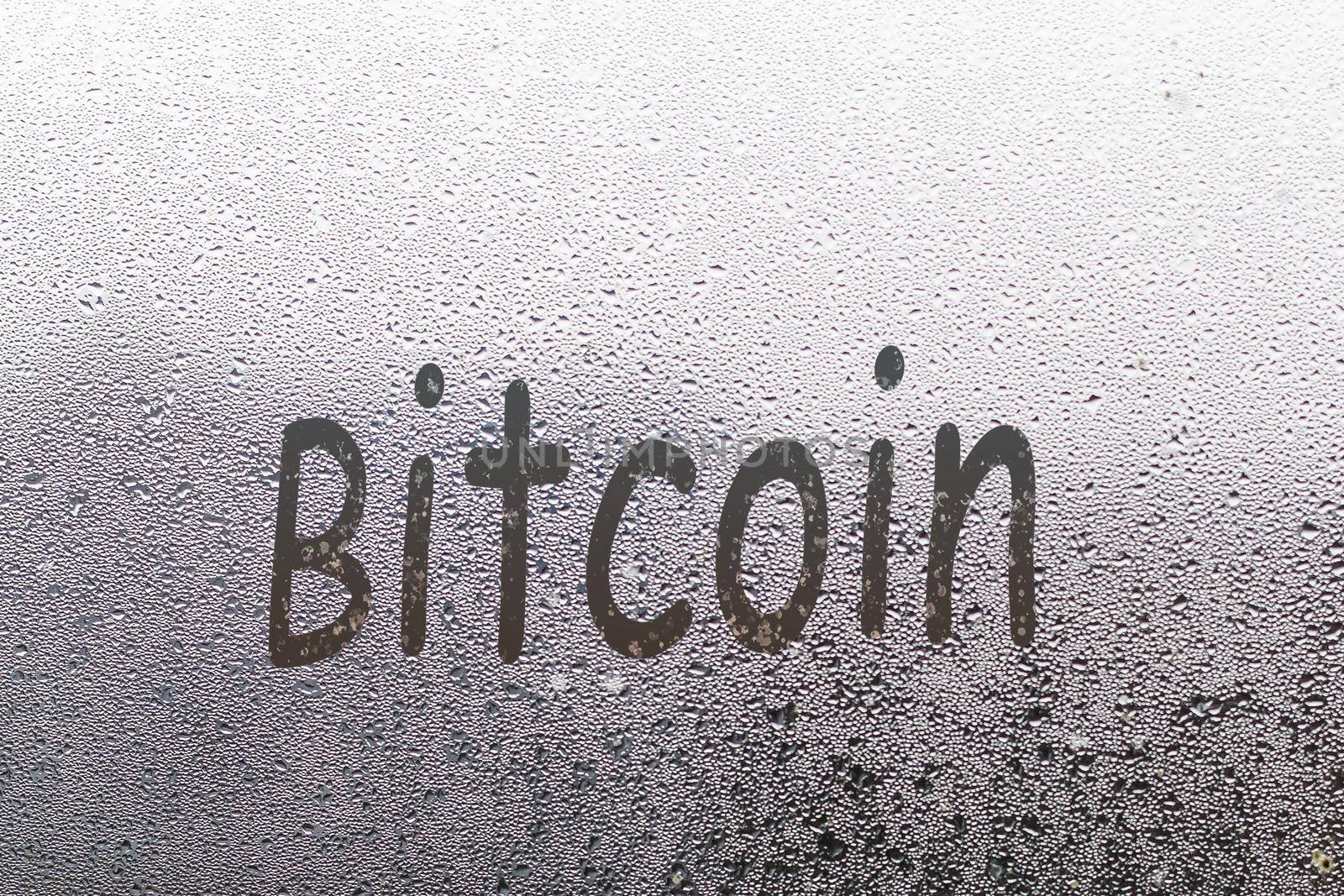 bitcoin handwritten on wet glass of night window by Andelov13