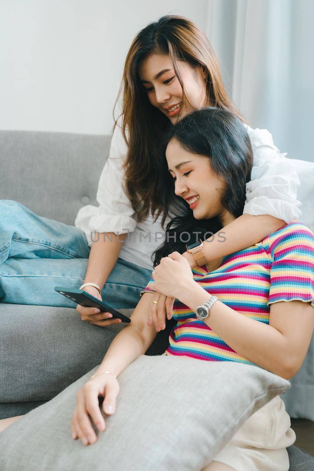 lgbtq, lgbt concept, homosexuality, portrait of two asian women enjoying together and showing love for each other while using smartphone mobile to take selfies by Manastrong