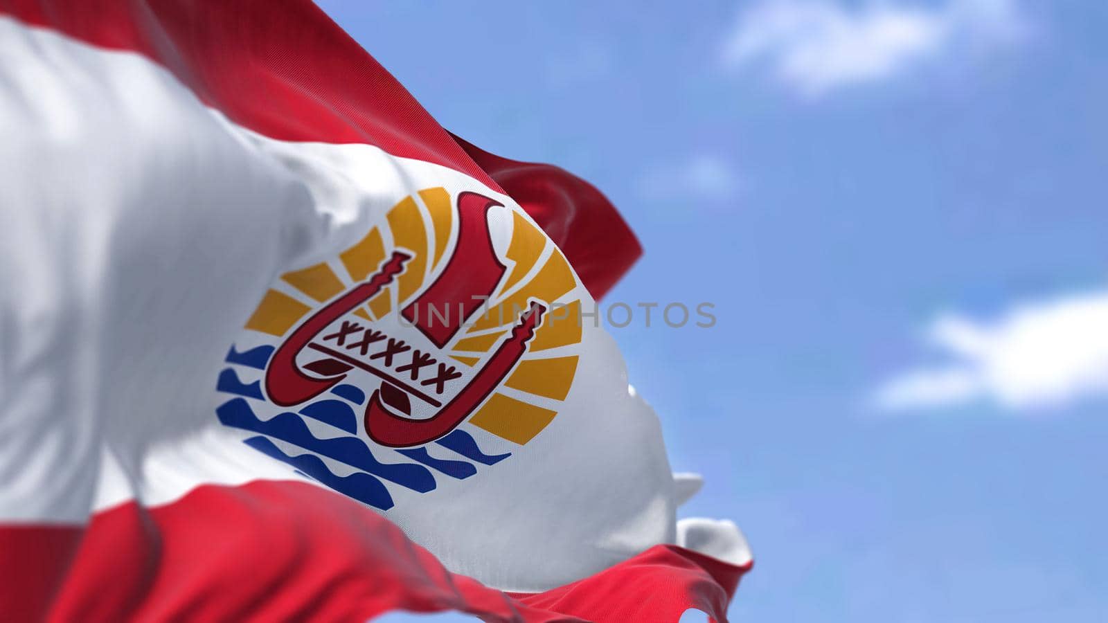 The flag of French Polynesia waving in the wind on a clear day. French Polynesia is an overseas collectivity of France and its sole overseas country