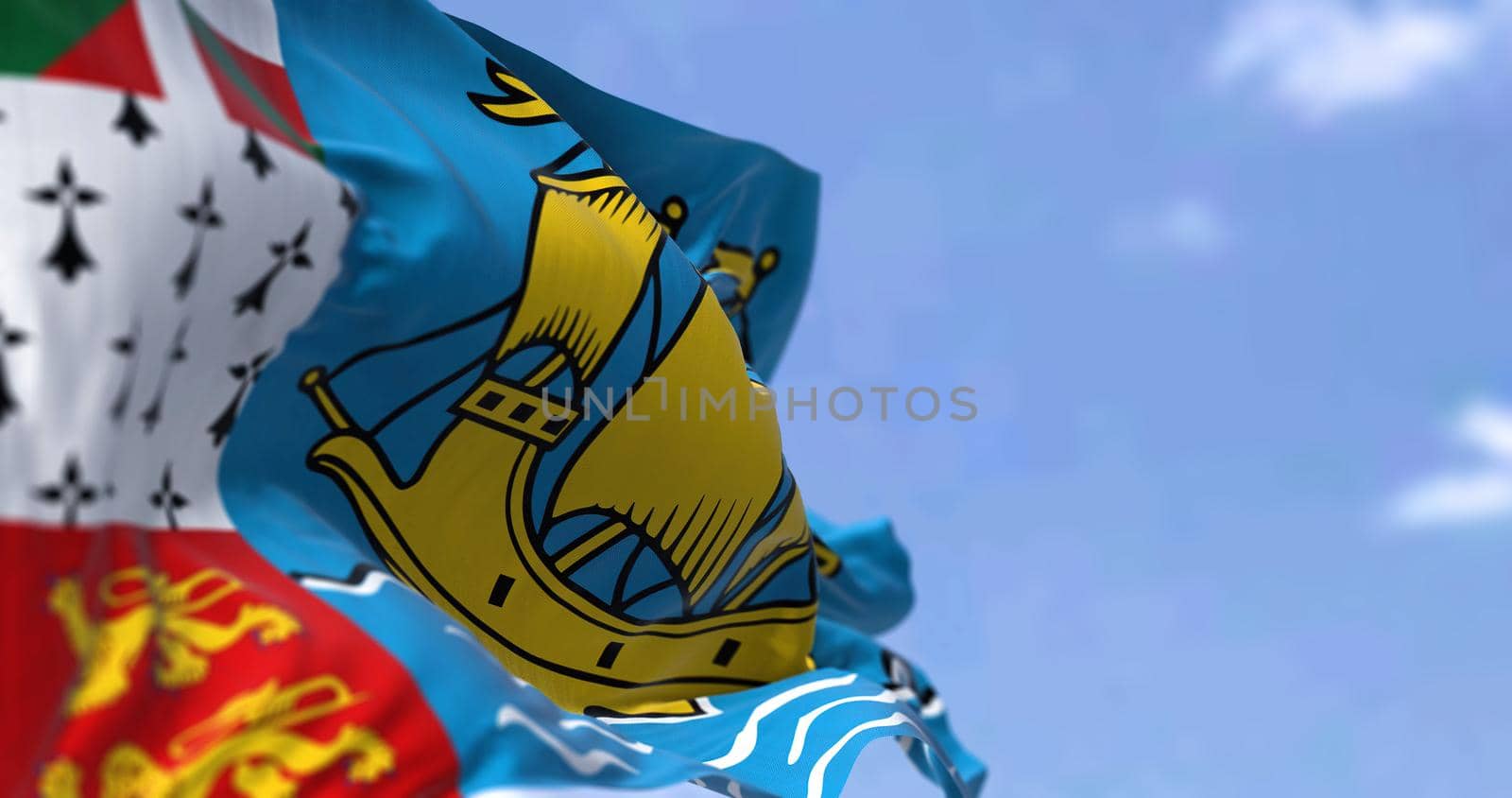 The flag of Saint Pierre and Miquelon waving in the wind on a clear day by rarrarorro