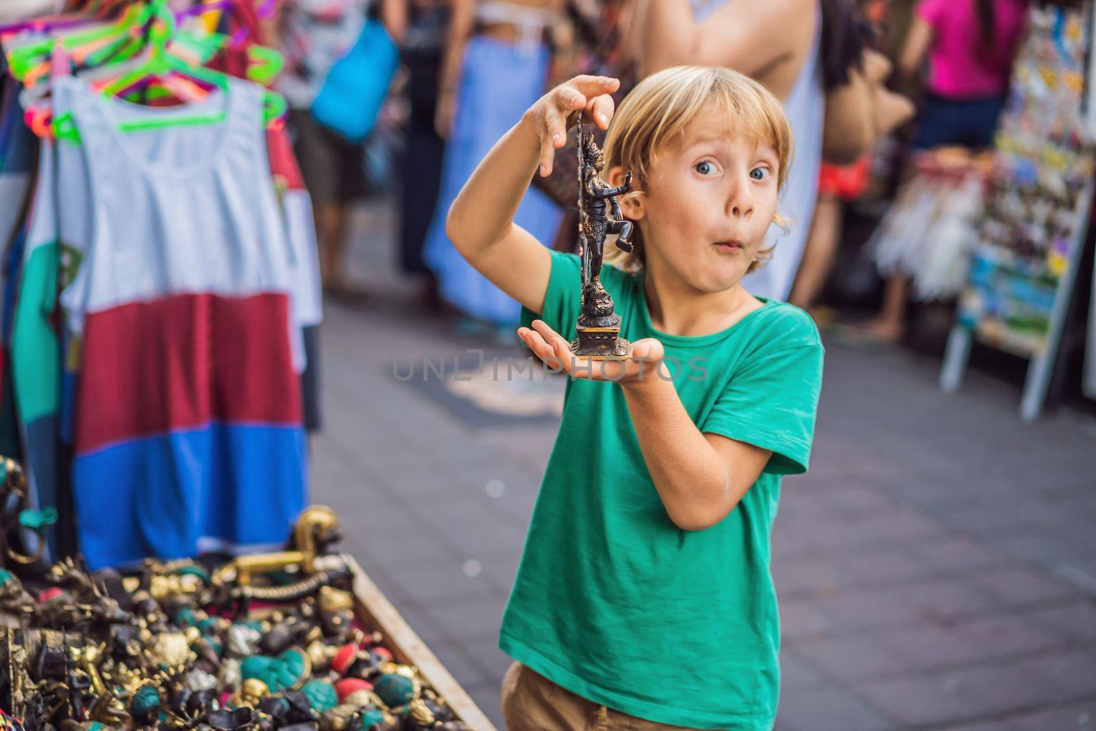 Boy at a market in Ubud, Bali. Typical souvenir shop selling souvenirs and handicrafts of Bali at the famous Ubud Market, Indonesia. Balinese market. Souvenirs of wood and crafts of local residents.