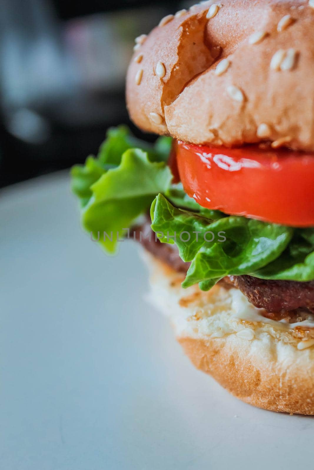 Homemade cheeseburger on white background with space, side view. Close-up burger.