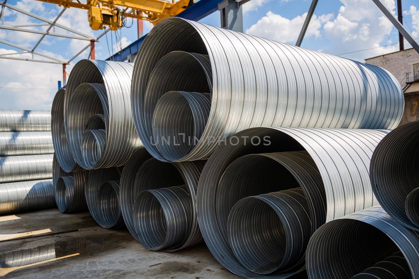 Ventilation pipe warehouse. Steel pipes, parts for the construction of air ducts for an industrial air conditioning system in a warehouse. Industrial airway ventilation equipment and piping systems.