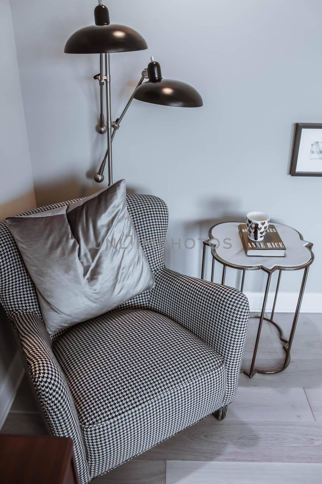 A reading chair armchair with a lamp, blanket and a open book. Empty white wall in simple living room interior. Copy space by JuliaDorian