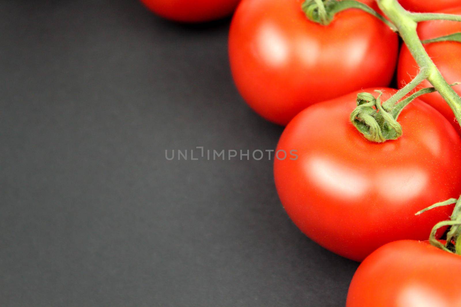 Red tomatoes on black background with water drops by JuliaDorian
