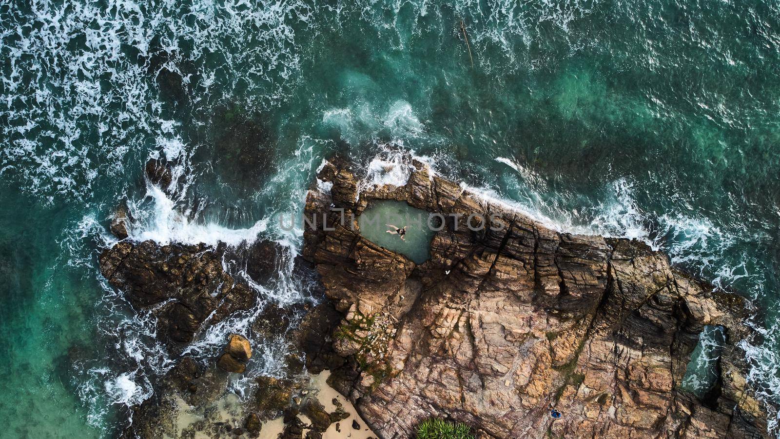 Aerial view of a girl who swims in a natural pool. View of Gurubebila natural sand pool. High quality photo