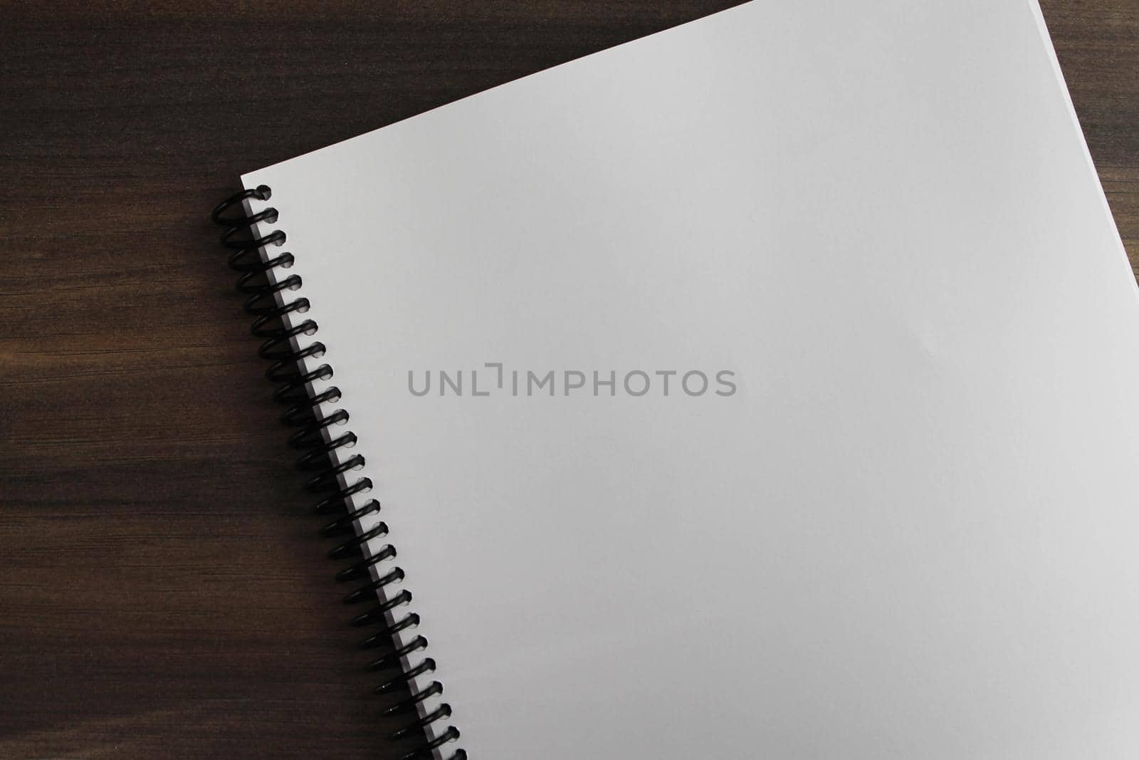 Spiral notepad paper on the wooden background. Empty. Space for text