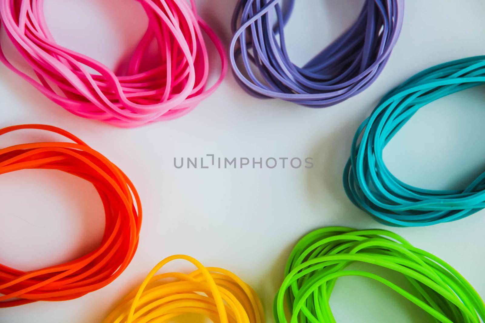 Top view of colorful rubber bands isolated on white. Rainbow elastic rubber bands on white. Close view