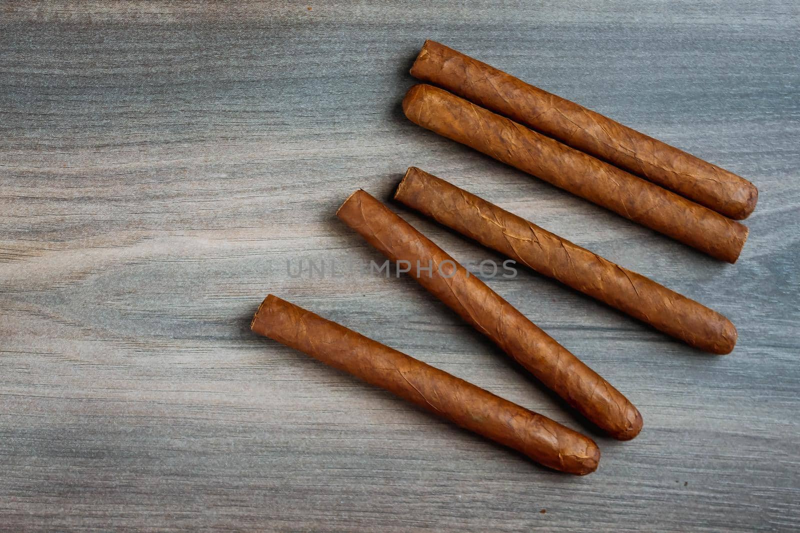 Close view of cigars on the wooden background by JuliaDorian