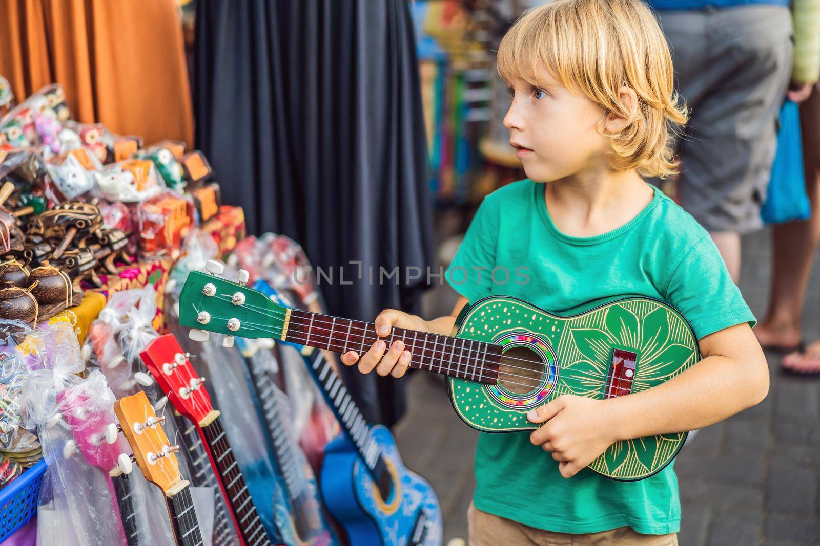 Boy at a market in Ubud, Bali. Typical souvenir shop selling souvenirs and handicrafts of Bali at the famous Ubud Market, Indonesia. Balinese market. Souvenirs of wood and crafts of local residents.