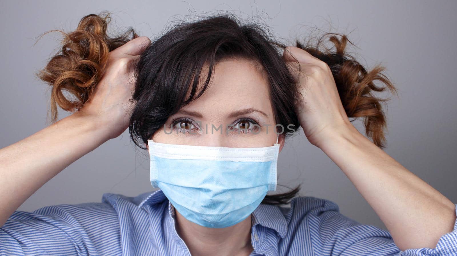 Woman wearing protection face mask against coronavirus. Woman in a mask making funny hair. Medical mask, Close up shot, Select focus, Prevention from covid19