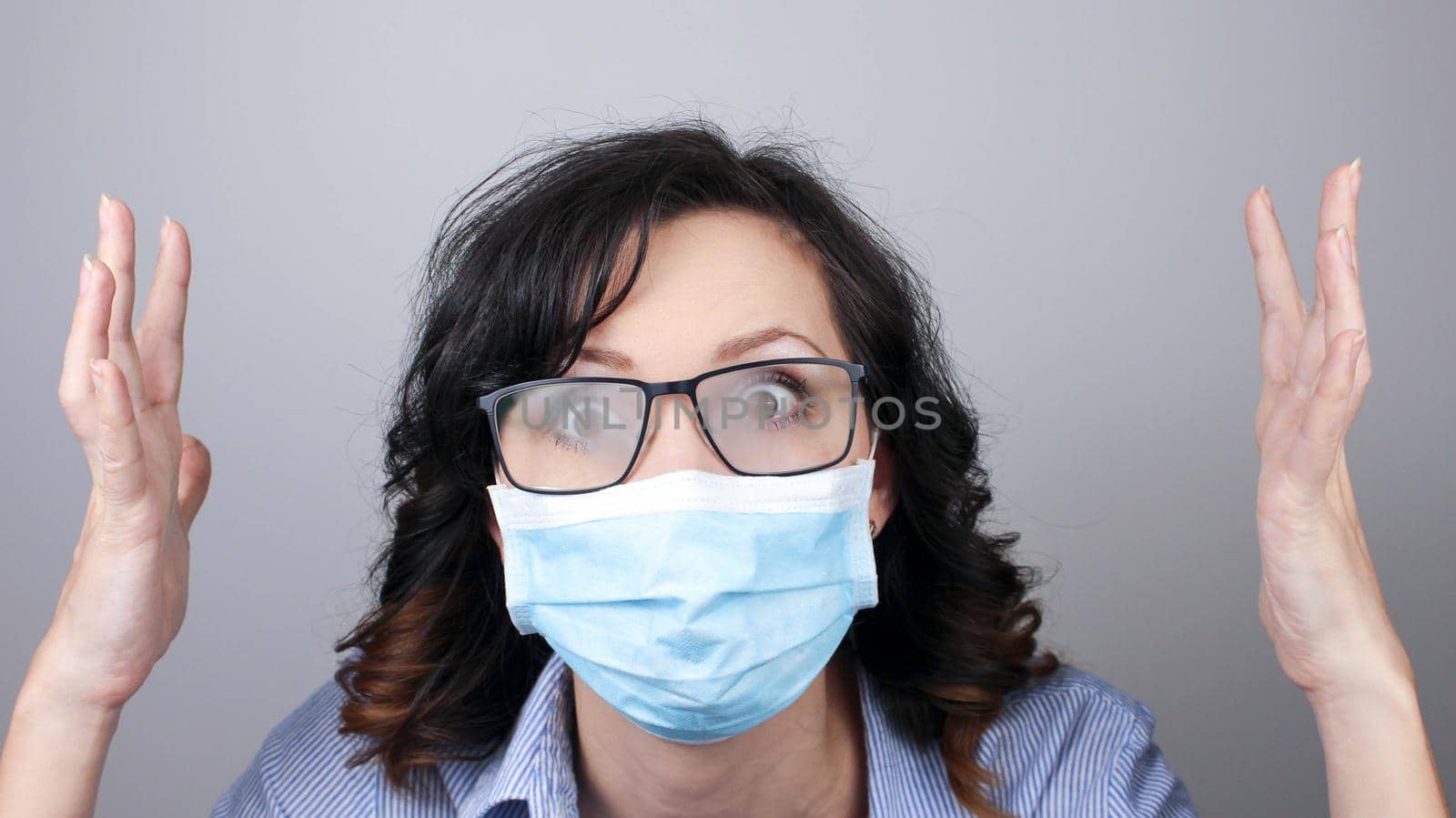 Woman wearing protection face mask against coronavirus and misted glasses. Woman in a mask looking shocked with hands up or worried. Medical mask, Close up shot, Select focus, Prevention from covid19