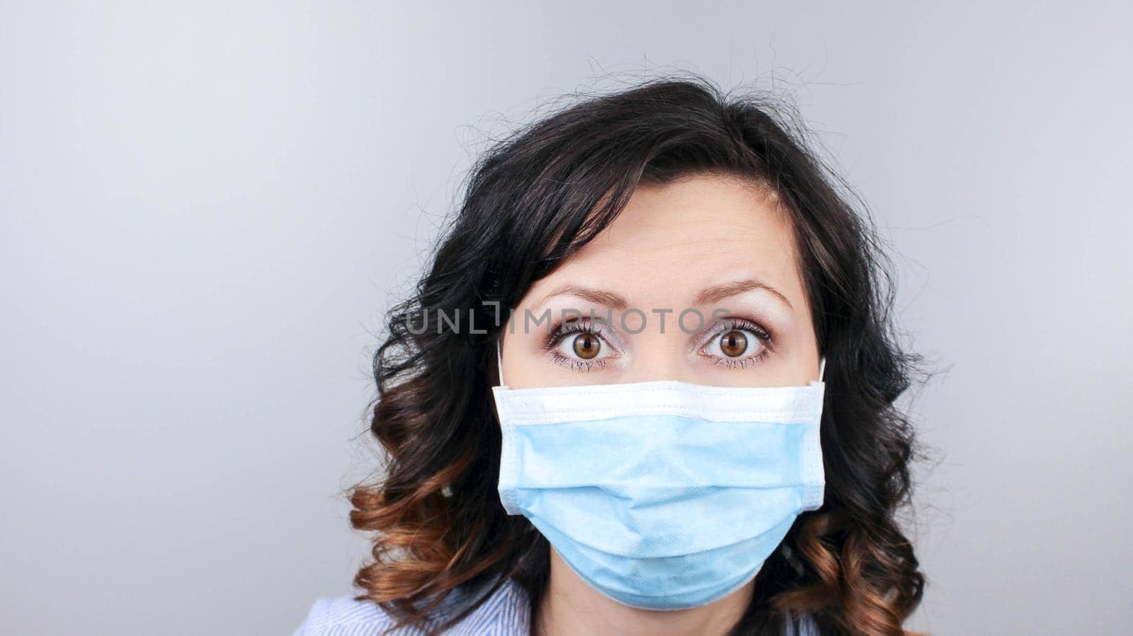 Woman wearing protection face mask against coronavirus. Woman in a mask looking shocked or worried with hands up. Medical mask, Close up shot, Select focus,