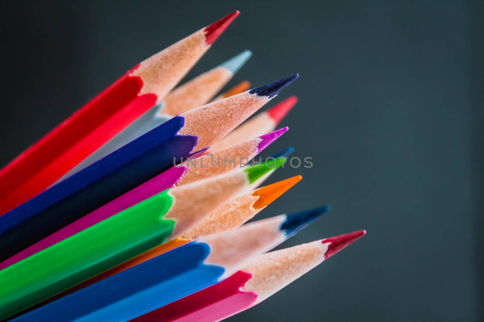 Tips of Colored pencils on black background. back to school. copy space