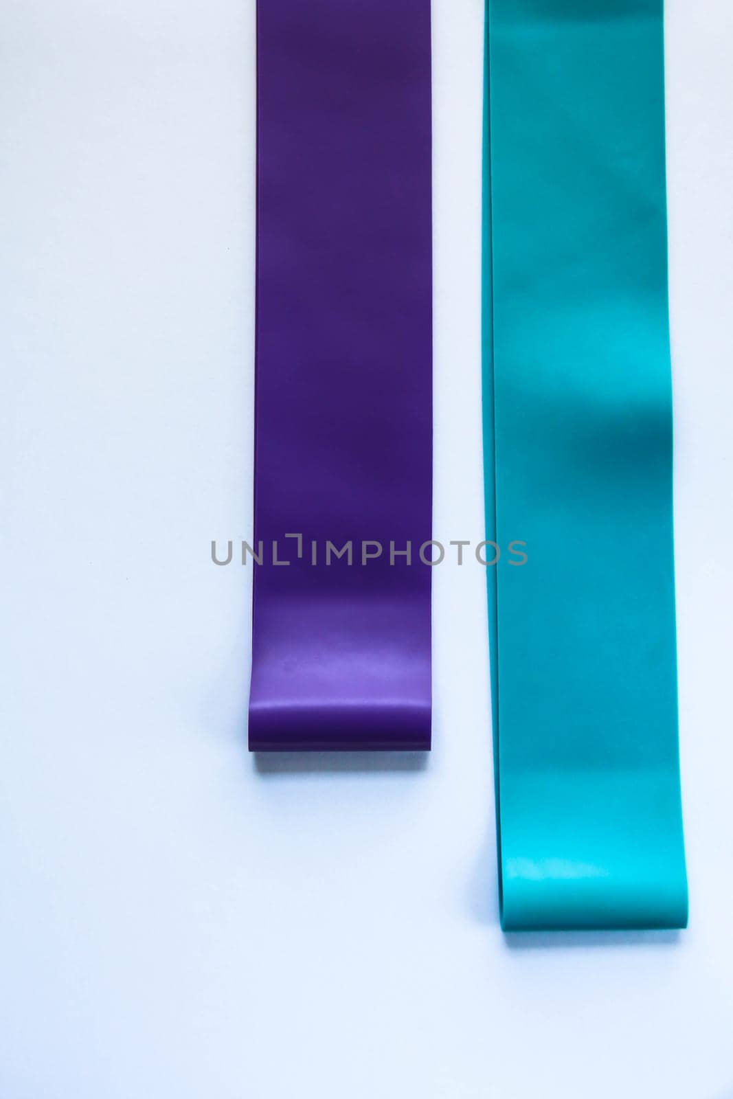 Fitness elastic band, elastic extenders of different colors for sports, isolated on a white background. Fitness trend by JuliaDorian