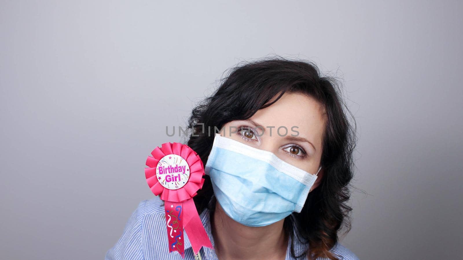 Woman wearing protection face mask against coronavirus. Woman in a mask with party supply. Birthday girl. Medical mask, Close up shot, Select focus, Prevention from covid19