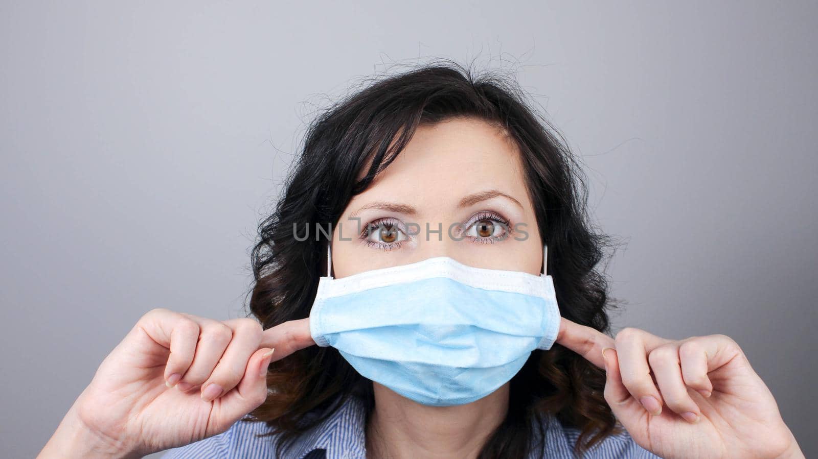 Woman wearing protection face mask against coronavirus. Woman in pulling mask away. Cannot breath. Removing face mask with fingers. Medical mask, Close up shot, Select focus, Prevention from covid19