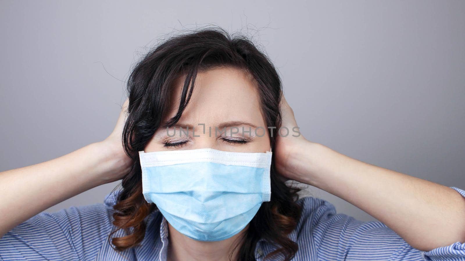 Woman wearing protection face mask against coronavirus. Cannot hear. Woman in a mask closing her ears. Medical mask, Close up shot, Select focus, Prevention from covid19