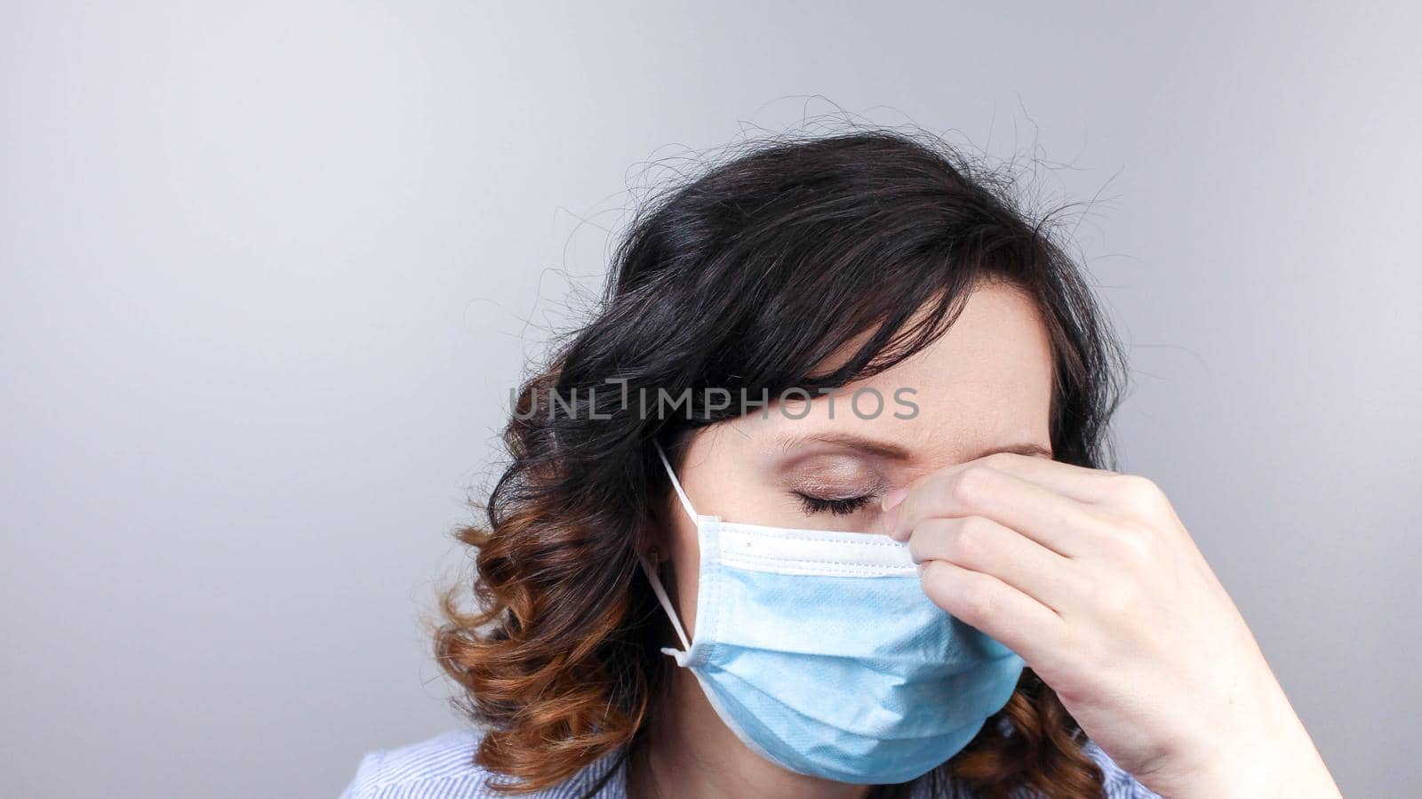 COVID-19 Pandemic Coronavirus Close up Sick Woman Headache Home Quarantine Wearing Surgical Mask Against SARS-CoV-2. Girl with headache isolate at home with mask against Coronavirus Disease 2019.