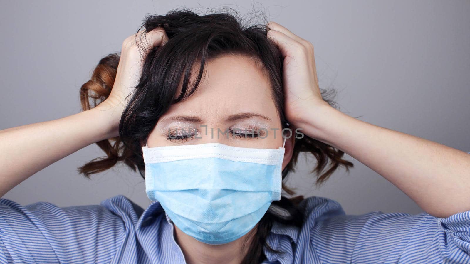 Woman wearing protection face mask against coronavirus. Cannot hear. Woman in a mask closing her ears. Medical mask, Close up shot, Select focus, Prevention from covid19