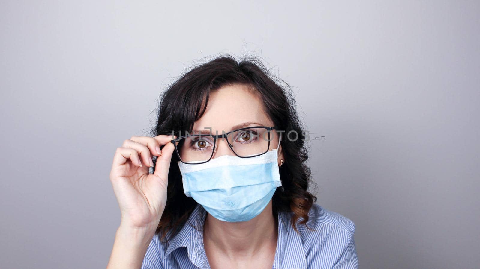 Woman wearing protection face mask against coronavirus. Woman in a mask and glasses. by JuliaDorian