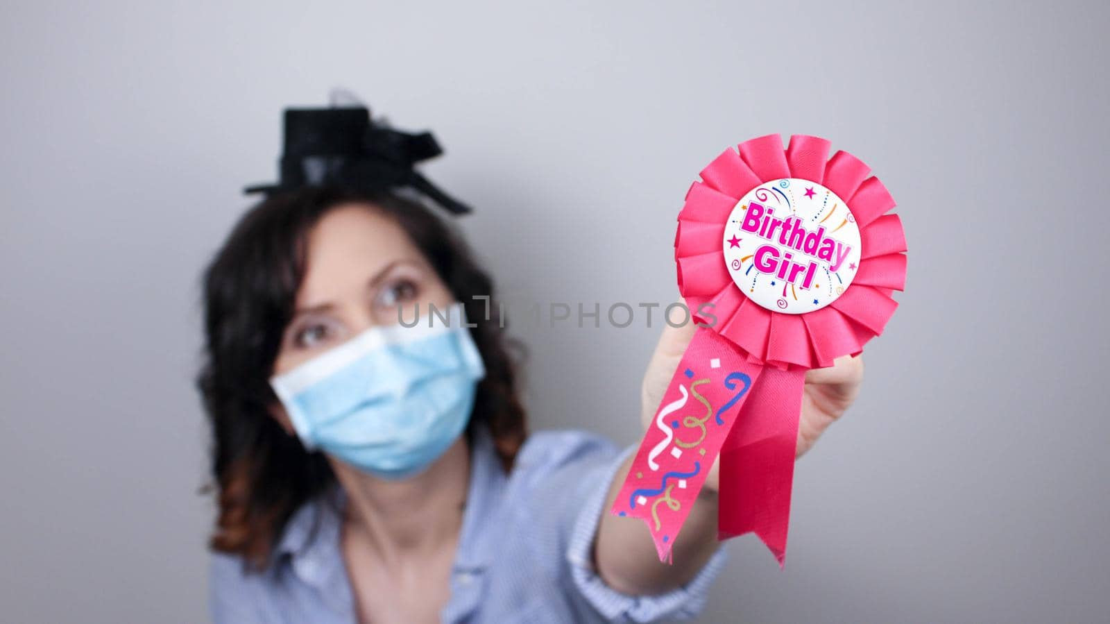 Woman wearing protection face mask against coronavirus. Woman in a mask with party supply. Birthday girl. Medical mask, Close up shot, Select focus, Prevention from covid19