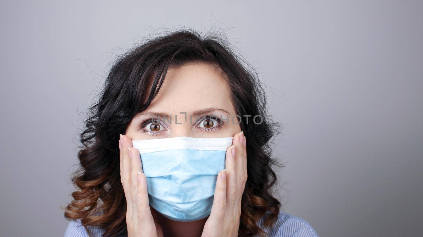 Woman wearing protection face mask against coronavirus. Cannot hear. Woman in a mask closing her ears. Medical mask, Close up shot, Select focus, Prevention from covid19
