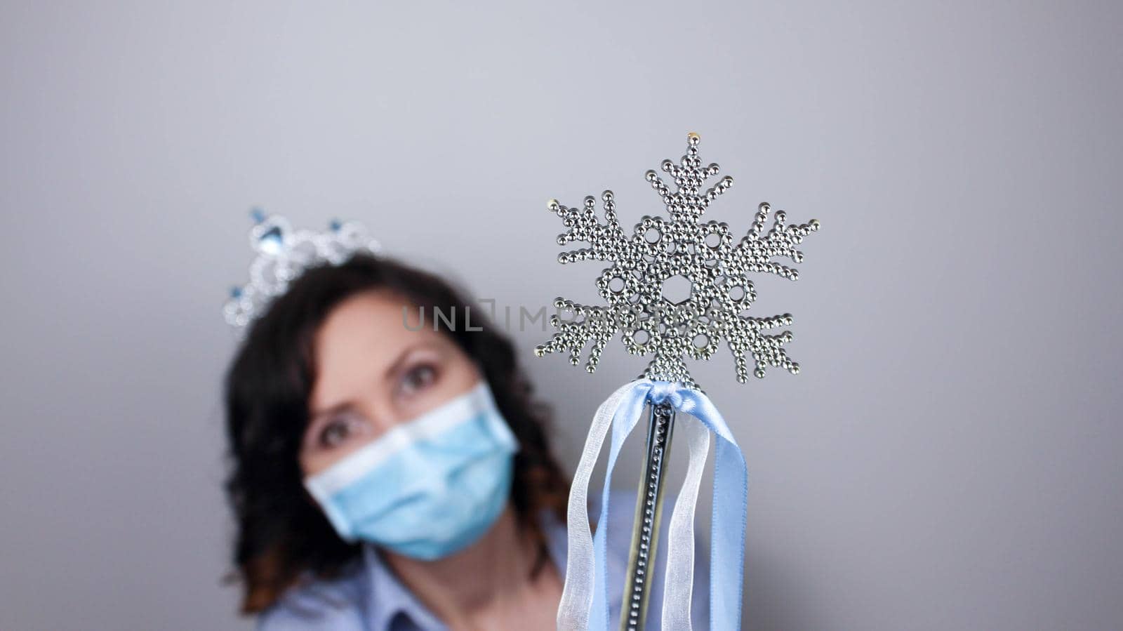 Woman wearing protection face mask against coronavirus. Woman in a mask and Christmas headband. Christmas, Halloween accessory. Medical mask, Close up shot, Select focus, Prevention from covid19