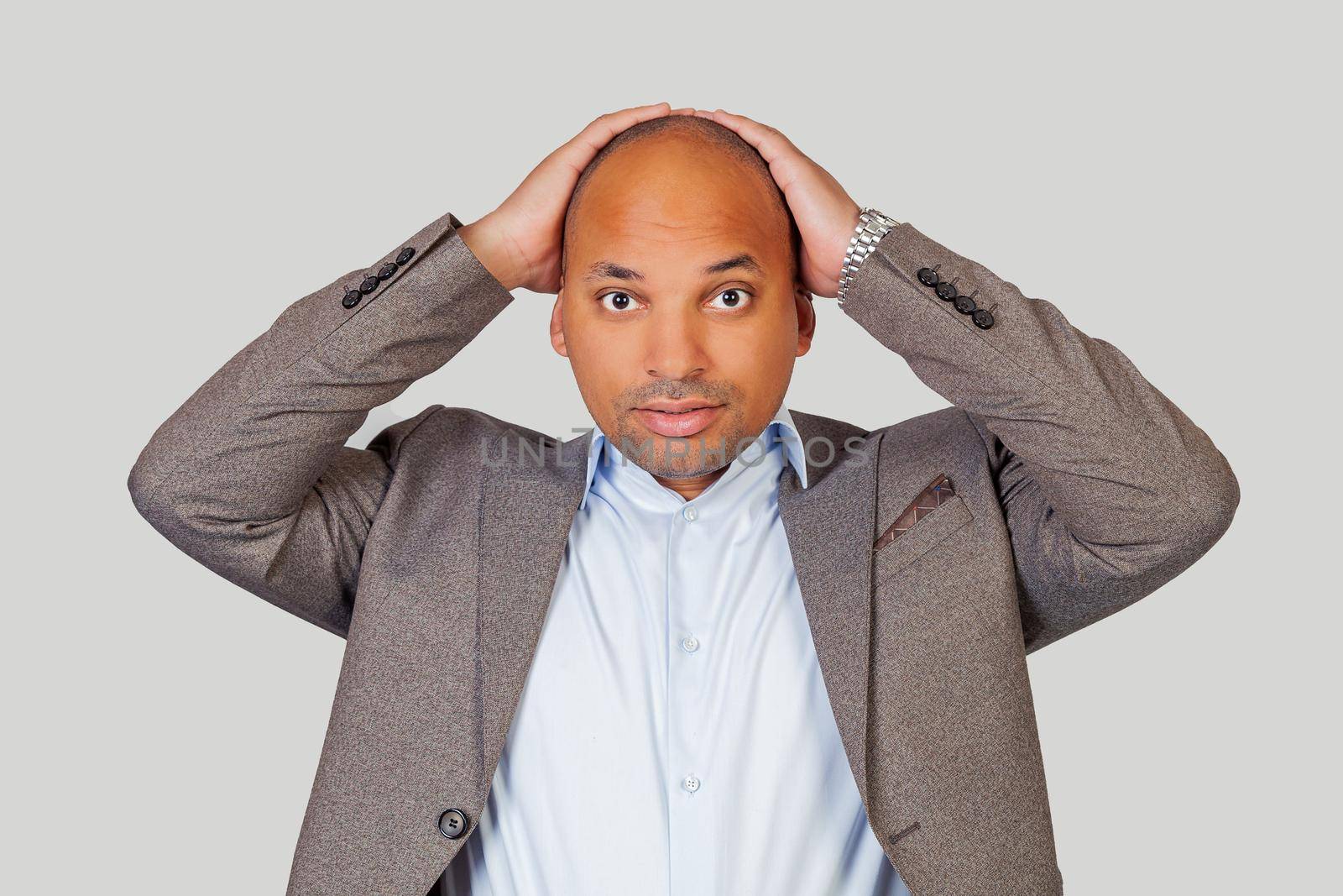 African american attractive guy holding head with hands having an awkward expression looking at his best friend who doing something stupid in public.