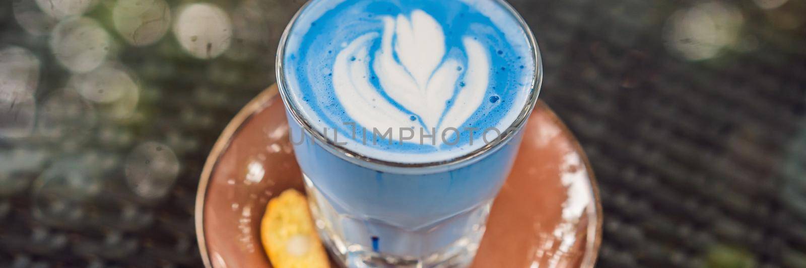 Trendy drink: Blue latte. Top view of hot butterfly pea latte or blue spirulina latte on gray textured background. Copy space for text BANNER, LONG FORMAT by galitskaya