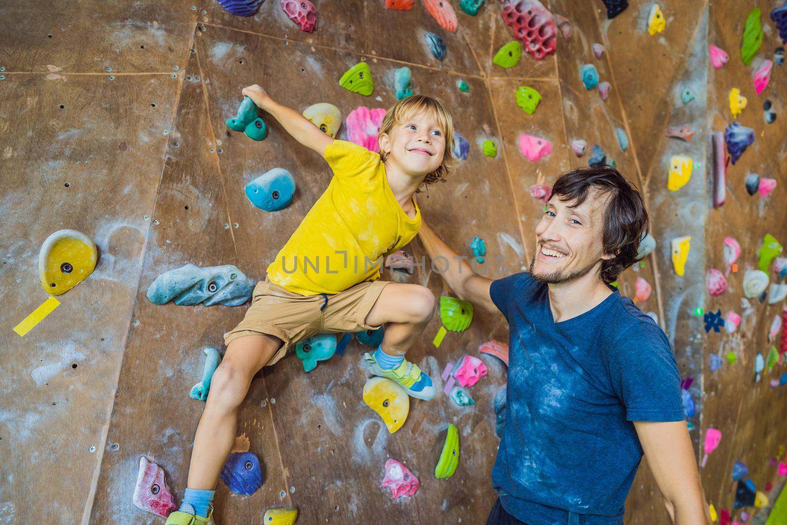 Dad and son at the climbing wall. Family sport, healthy lifestyle, happy family.