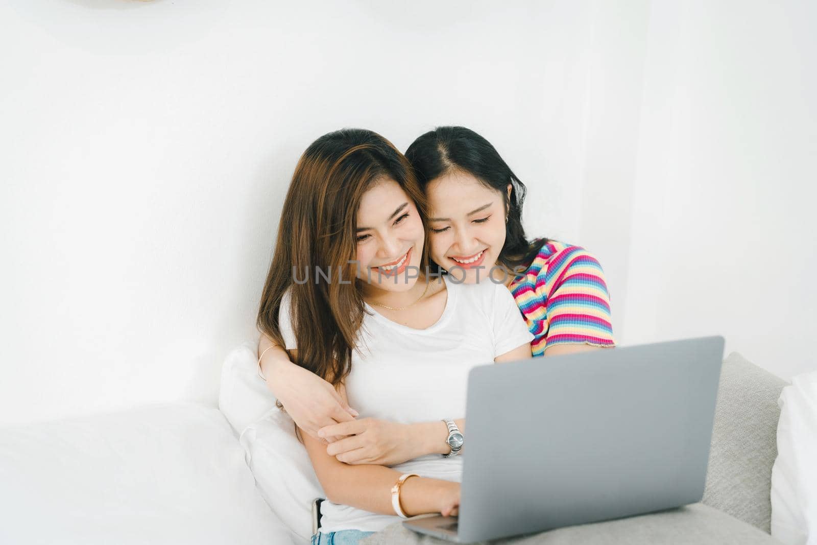 lgbtq, lgbt concept, homosexuality, portrait of two asian women posing happy together and loving each other while playing computer laptop on bed.