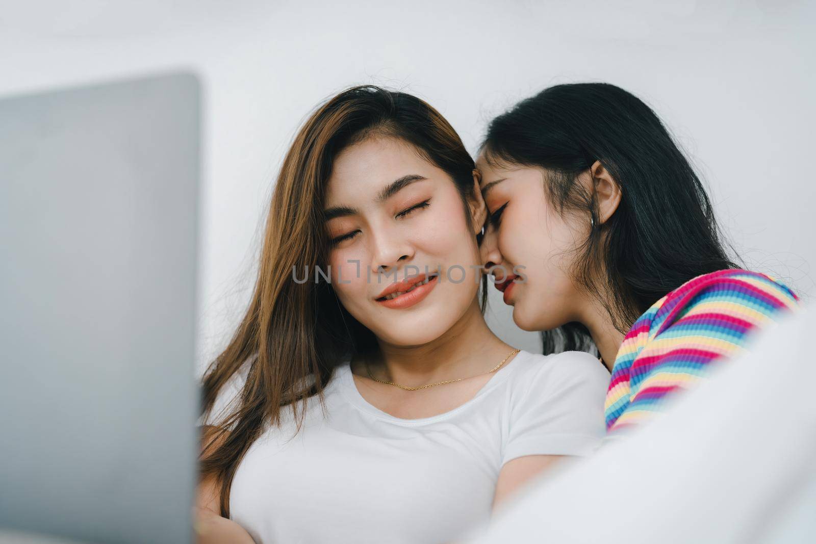 lgbtq, lgbt concept, homosexuality, portrait of two asian women posing happy together and loving each other while playing tablet on bed.