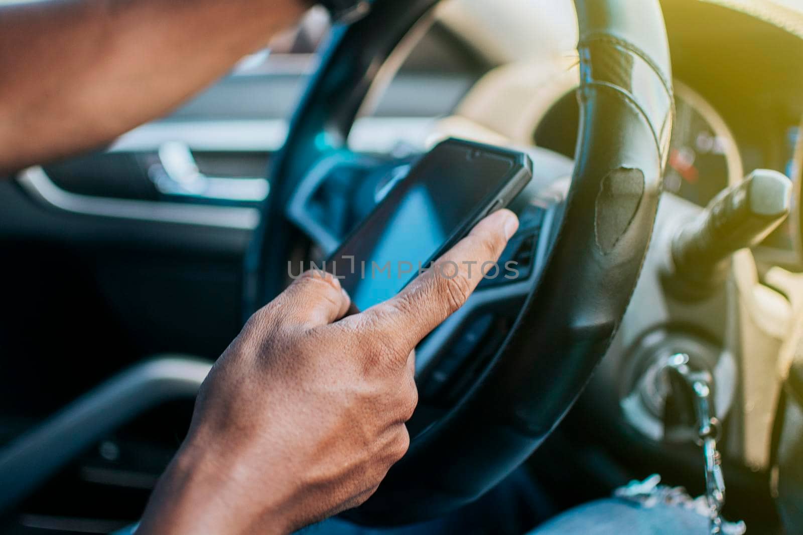 Close up of driver hands using his phone, Person in his car using cell phone, Concept driver hands touching cell phone screen