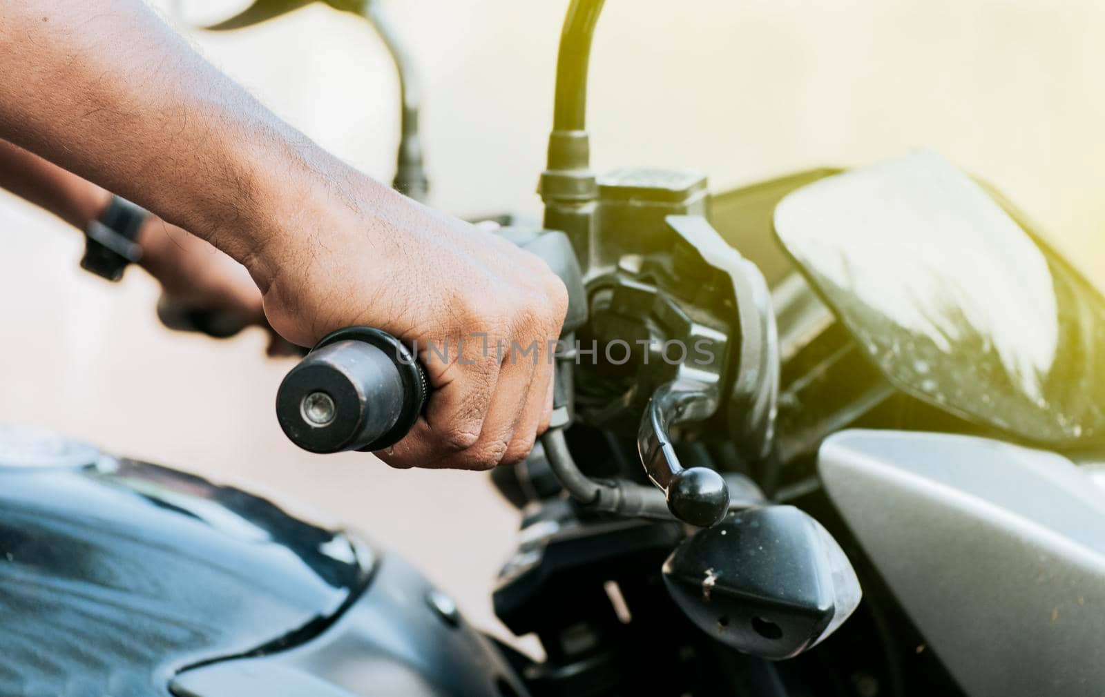 Hands of a person on the handlebar of a motorcycle, Close up of the hands of a motorcycle driver, Close up of hands on the handlebar of a motorcycle