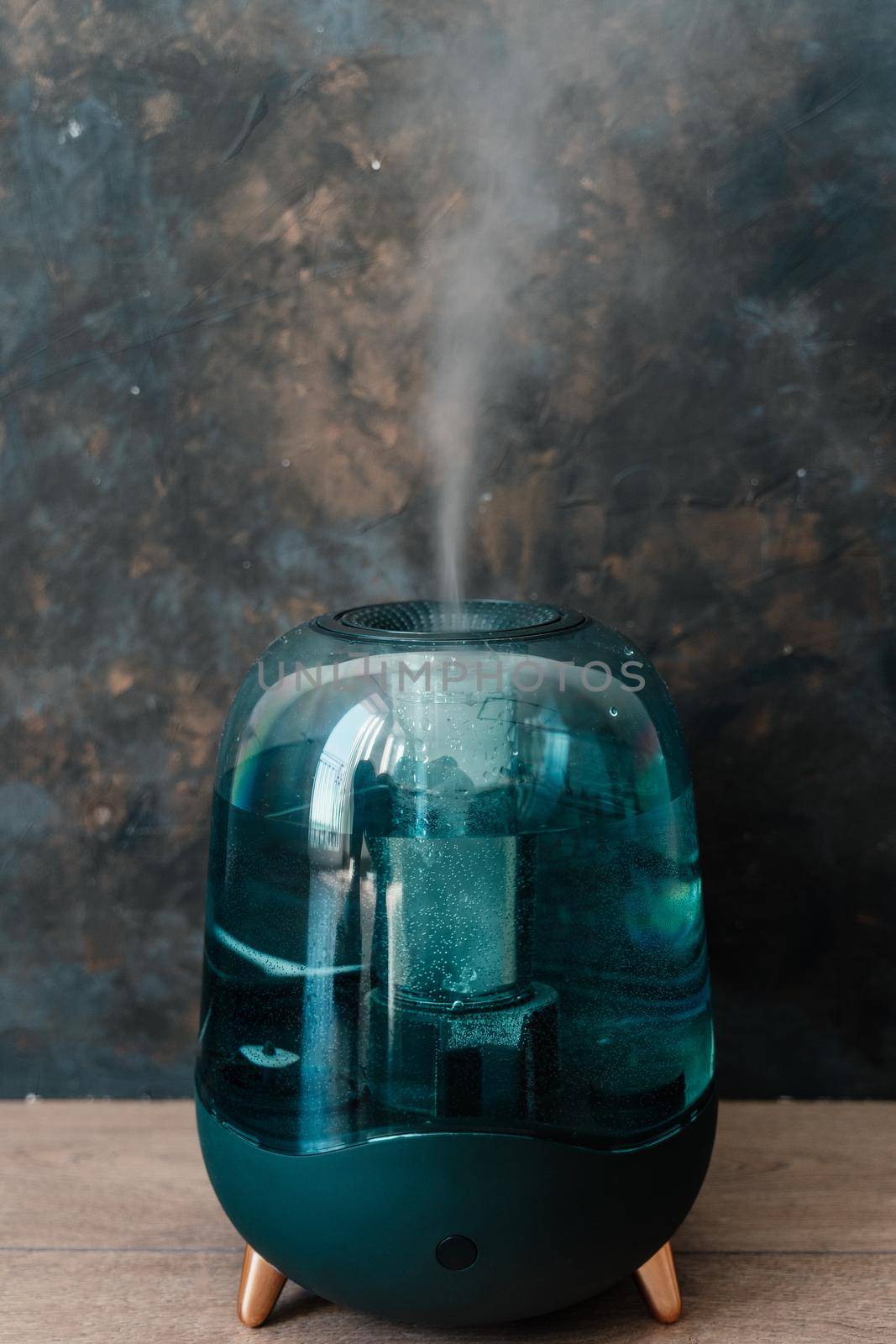 Modern air humidifier on a dark background. Humidifier spreading steam into the living room.