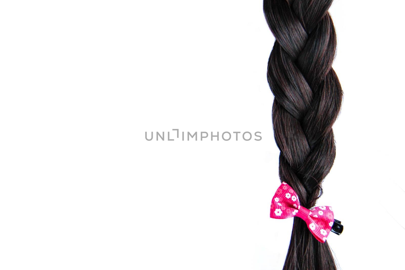 Black braided hair isolated on white background. Brunette natural braided hair extension on white background