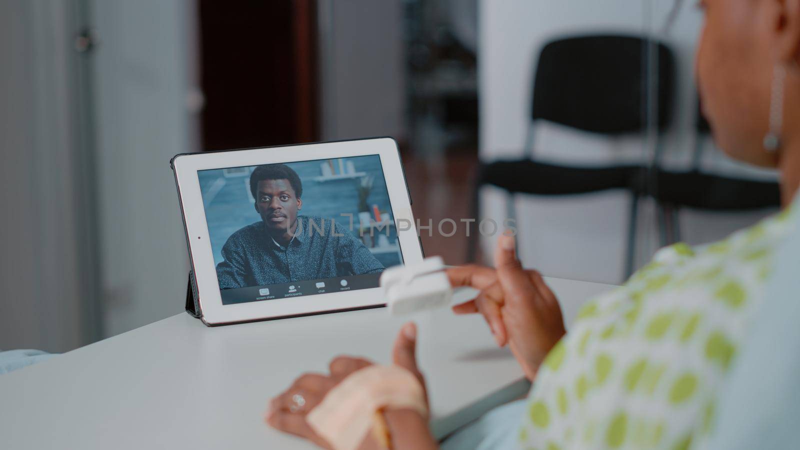 Close up of patient using video call on digital tablet by DCStudio